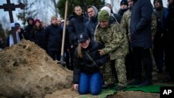 Anya Korostenska drops to her knees at the grave of her fiance Oleksiy Zavadskyi, a Ukrainian serviceman who died in combat on January 15 in Bakhmut, during his funeral in Bucha, Ukraine.
