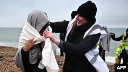 FILE - Volunteers from the refugee crisis charity Care4Calais gives a migrants, picked up at sea attempting to cross the English Channel, a dry blanket at Dungeness on the southeast coast of England, on December 9, 2022. 