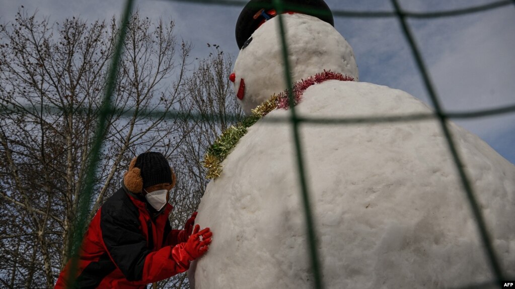 北京降雪后一名男子搭起一个雪人。(2023年1月23日)(photo:VOA)
