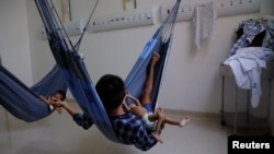 Yanomami indigenous children being treated for malnutrition lie on hammocks with their father at the special ward for indigenous people of the Santo Antonio Children's Hospital in Boa Vista, Brazil, Jan. 27, 2023.