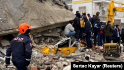 Orang-orang mencari korban di balik puing-puing setelah gempa bumi di Diyarbakir, Turki 6 Februari 2023. (Foto: REUTERS/Sertac Kayar)