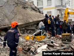 Orang-orang mencari korban di balik puing-puing setelah gempa bumi di Diyarbakir, Turki 6 Februari 2023. (Foto: REUTERS/Sertac Kayar)