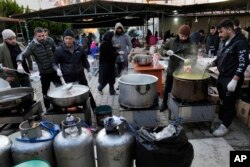 FILE Volunteers cook for Syrians at a shelter in Antakya, southeastern Turkey, Feb. 10, 2023. For Syrians and Ukrainians fleeing the violence back home, the earthquake that struck in Turkey and Syria is but the latest tragedy.