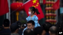 资料照：在北京一个购物区一名小女孩骑在一个男子的肩头上逛街。(2022年10月7日)
