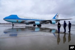 Military officers look on as Air Force One, with President Joe Biden, prepares for takeoff Jan. 31, 2023, en route to New York. (AP Photo/Jess Rapfogel)