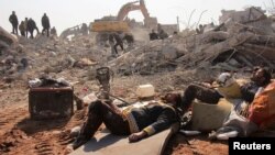 Anggota Tim SAR White Helmets beristirahat di hari kelima operasi penyelamatan pasca gempa dahsyat di Jandaris, Suriah 10 Februari 2023. (Foto: via Reuters)