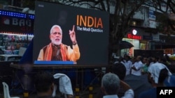 People watch the BBC documentary "India: The Modi Question", on a screen installed at the Marine Drive junction under the direction of the district Congress committee, in Kochi, Jan. 24, 2023.