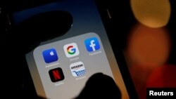 Foto ilustrasi berikut menampilkan logo dari sejumlah aplikasi seperti Google, Netflix, Facebook, Amazon dan Apple pada sebuah layar telepon genggam. Foto diambil pada 3 Desember 2019. (Foto: Reuters/Regis Duvignau)