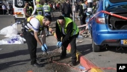 FILE -Members of Zaka Rescue and Recovery team work at the site of a car-ramming attack at a bus stop in a Jewish settlement in east Jerusalem, Feb. 10, 2023. 