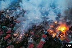 FILE - Smoke billows from properties at Thantlang in Chin State, Oct. 29, 2021, where more than 160 buildings have been destroyed caused by shelling from Junta military troops, according to local media.