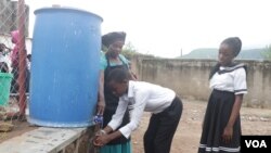 छात्र अपने स्कूल के हैजा से बचाव के उपायों के पालन में हाथ धोते हैं।  (लैमेक मसीना / वीओए)