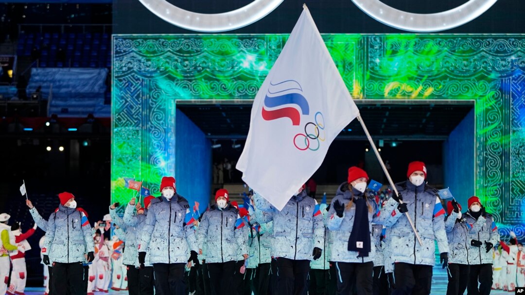 FILE- Olga Fatkulina dan Vadim Shipachyov membawa bendera ke dalam stadion saat upacara pembukaan Olimpiade Musim Dingin 2022 di Beijing, 4 Februari 2022. Para atlet Rusia berkompetisi di bawah bendera ROC (Komite Olimpiade Rusia), untuk ketiga kalinya. (AP/Jae C. Hong, File)