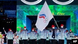 FILE- Olga Fatkulina dan Vadim Shipachyov membawa bendera ke dalam stadion saat upacara pembukaan Olimpiade Musim Dingin 2022 di Beijing, 4 Februari 2022. Para atlet Rusia berkompetisi di bawah bendera ROC (Komite Olimpiade Rusia), untuk ketiga kalinya. (AP/Jae C. Hong, File)