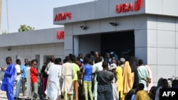 FILE - People line up to withdraw new naira notes at an ATM in Maiduguri, Nigeria, on Jan. 29, 2023. The shortage of new naira has prompted Abuja to allow the old currency notes back into circulation - for now.
