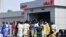 FILE - People line up to withdraw new naira notes at an ATM in Maiduguri, Nigeria, on Jan. 29, 2023. The shortage of new naira has prompted Abuja to allow the old currency notes back into circulation - for now.
