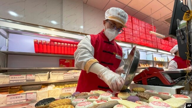 A worker packs a new year gift box with traditional pastries at a branch of Daoxiangcun, one of the best-known Chinese bakeries in Beijing, China, on Jan. 14, 2023.