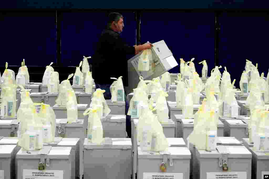 An election official lifts a ballot box before they are distributed to polling stations, in Nicosia, Cyprus.