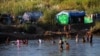 FILE - Refugees, who have fled fighting in Myanmar, bathe in the river on the Thai-Myanmar border, in Mae Sot, Thailand, Jan. 7, 2022. 