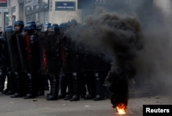 French police stand on position amid clashes with protesters during a demonstration against French government's pension reform plan in Paris, France, Jan. 31, 2023.