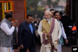 Indian Prime Minister Narendra Modi, right, gestures to his cabinet colleagues as he arrives on the opening day of the Parliament's budget session, in New Delhi, India, Jan. 31, 2023.