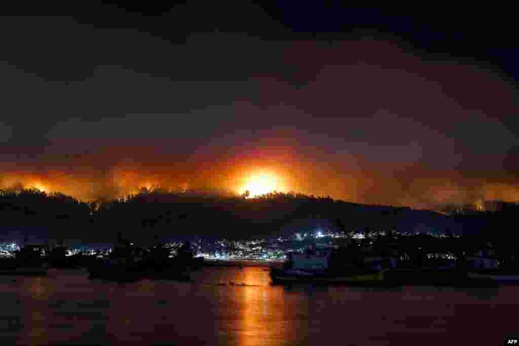 A forest fire approaches the town of Dichato in the southern region of Chile, where forest fires have raged for more than a week, leaving at least 24 people dead.