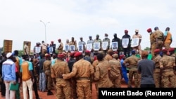 Soldiers hold portraits at the funeral of soldiers killed in an attack by Islamist militants on a convoy in Burkina Faso.