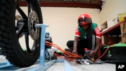 FILE - Alex Thuo, an employee at Ecobodda mobility, works on an electric motorcycle at its warehouse in Nairobi, Kenya, Jan. 23, 2023.
