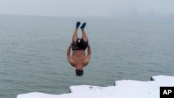 "The Great Lake Jumper" Dan O'Conor takes a plunge into the frigid waters of Lake Michigan, as he does every morning, Thursday, Jan. 26, 2023, in Chicago.(AP Photo/Erin Hooley)