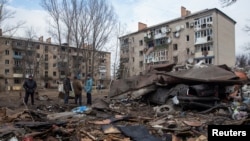 Local residents stand at a site of a Russian missile strike, amid Russia's attack on Ukraine, in Kostiantynivka, Donetsk region, Ukraine, Jan, 28, 2023. 