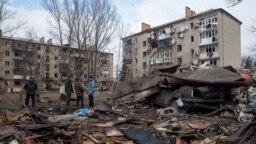 Cư dân địa phương đứng cạnh một địa điểm bị Nga tên lửa của Nga đánh trúng ở thành phố Kostiantynivka, Donetsk, Ukraine, ngày 28 tháng 1 năm 2023.
