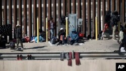 FILE - Migrants wait on the the border between Mexico and the United states, as seen from Ciudad Juarez, Mexico, Jan. 8, 2023.