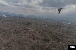 Esta vista aérea muestra a desplazados internos (IDP, por sus siglas en inglés) que transportan carbón desde el bosque al pie del volcán Nyiragongo en el Parque Nacional Virunga, el 14 de enero de 2023, al mercado en Kibati.  El bosque del volcán Nyiragongo pronto no será más que tocones.