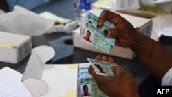 FILE - An official of the Independent National Electoral Commission (INEC) sorts Permanent Voters card (PVC) of voters at a ward in Lagos, Nigeria, Jan. 12, 2023.