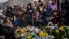 Nadia, center, prays at the grave of her son Oleg Kunynets, a Ukrainian military servicemen who were killed in the east of the country, during his funeral in Lviv, Feb 7, 2023.