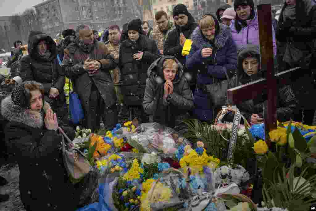 Nadia, center, prays at the grave of her son Oleg Kunynets, a Ukrainian military serviceman who was killed in the east of the country, during his funeral in Lviv.