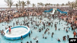 FILE - Revelers gather at North Pier Beach swimming pools in Durban, South Africa, Jan. 1, 2020. Just one South African in seven knows how to swim, the National Sea Rescue Institute says. Container pools are now being used to teach children to float.