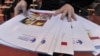 FILE - A worker lays out copies of corruption watchdog Transparency International's annual Corruption Perceptions Index prior to a press conference upon the release of the document, in Berlin, Oct. 26, 2010. 