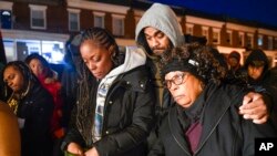 FILE - Tammy Chance, left, mother of Jalil George, 24, who was fatally shot Dec. 7, 2022, in Baltimore, stands with George's stepfather and grandmother during a vigil for George, Dec. 14, 2022, in Baltimore.