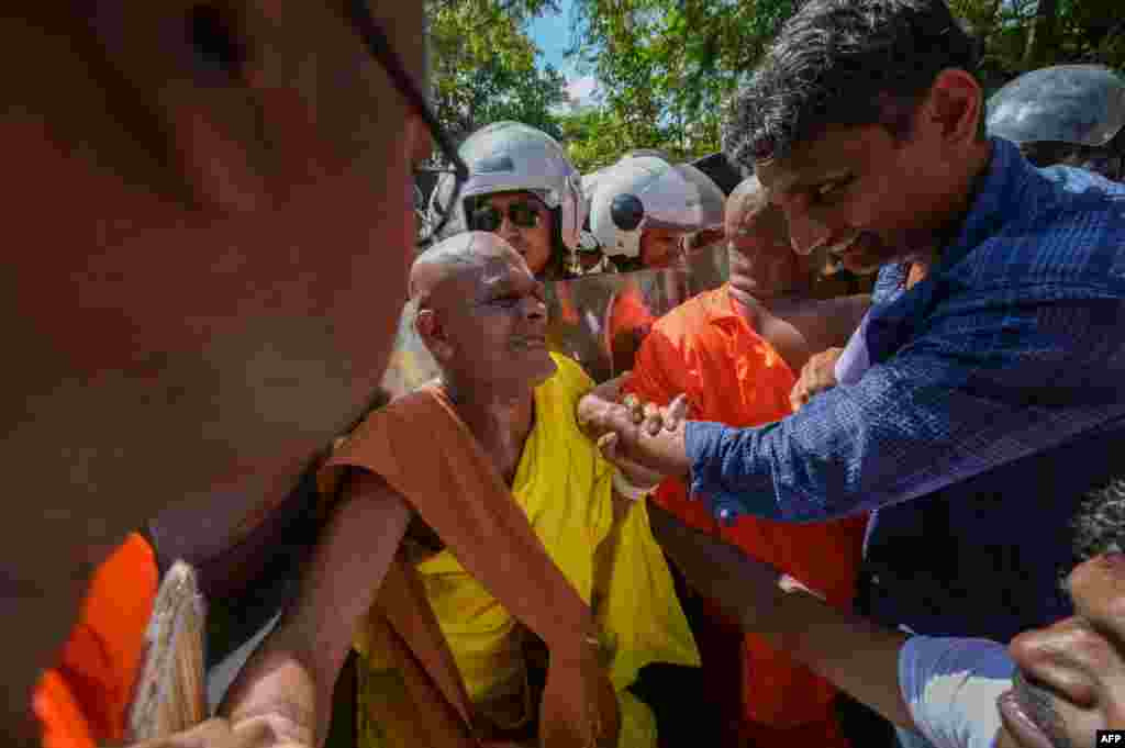 A group of hardline Buddhist monks and anti-government demonstrators scuffle with police near the parliament during a protest against the President Ranil Wickremesinghe&#39;s plan to devolve powers to minority Tamils, in Colombo.