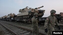 Soldados estadounidenses caminan junto a tanques M1 Abrams en la base aérea Mihail Kogalniceanu, Rumania, 14 de febrero de 2017.