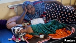FILE - Somali displaced mother Binti Moalim Hassan lays beside her malnourished 3-year-old daughter Faduma in a hospital in Mogadishu, Oct. 25, 2022.