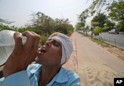 Seorang buruh minum air untuk melepas dahaga di hari yang panas di New Delhi, India, Senin, 2 Mei 2022. Ibu kota India, seperti banyak bagian Asia Selatan lainnya, tengah dilanda gelombang panas yang memecahkan rekor. (AP/Manish Swarup)