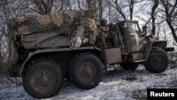 Militares ucranianos viajan en un sistema de cohetes de lanzamiento múltiple BM-21 Grad mientras se preparan para dispararlo hacia las posiciones rusas en una línea de frente cerca de la ciudad de Marinka, en la región de Donetsk, Ucrania, el 7 de febrero de 2023. 