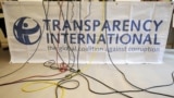 FILE - Microphone cables dangle over a logo of Transparency International during a press conference in Berlin, Sept. 23, 2008.