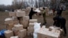 FILE - People handle boxes with humanitarian aid after an apartment block was heavily damaged by a Russian missile strike, amid Russia's attack on Ukraine, in Dnipro, Ukraine, Jan. 16, 2023. 