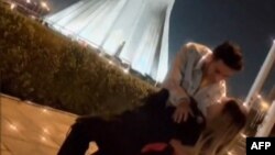 This image grab taken from a UGC video posted on Twitter on Jan. 29, 2023, shows Astiyazh Haghighi and her fiance, Amir Mohammad Ahmadi, dancing in front of Tehran's Azadi Tower. (AFP/ESN/HENGAW)