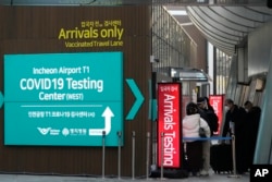 资料照 - 韩国卫生部门规定来自中国的旅客到达韩国后必须进行新冠病毒检测。2023年1月1号，韩国仁川国际机场旅客到达处，红牌上写着到达旅客检测。