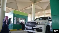 Visitors show their documents to Saudi customs officials as they travel from Qatar through the Salwa crossing between the two countries, Jan. 10, 2021.