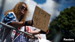 Una partidaria del expresidente Donald Trump sostiene una pancarta contra la MS-13 durante un foro sobre la Mara Salvatrucha (MS-13) con sede en América Central en el Centro de Seguridad Nacional Morrelly en Bethpage, Nueva York, EE. UU., el 23 de mayo de 2018.