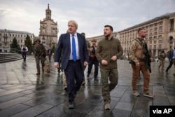 En esta imagen proporcionada por la Oficina de Prensa Presidencial de Ucrania, el presidente ucraniano Volodymyr Zelenskyy, en el centro a la derecha, y el primer ministro británico, Boris Johnson, en el centro a la izquierda, caminan durante la visita de Johnson en el centro de Kiev, Ucrania, el 9 de abril de 2022.